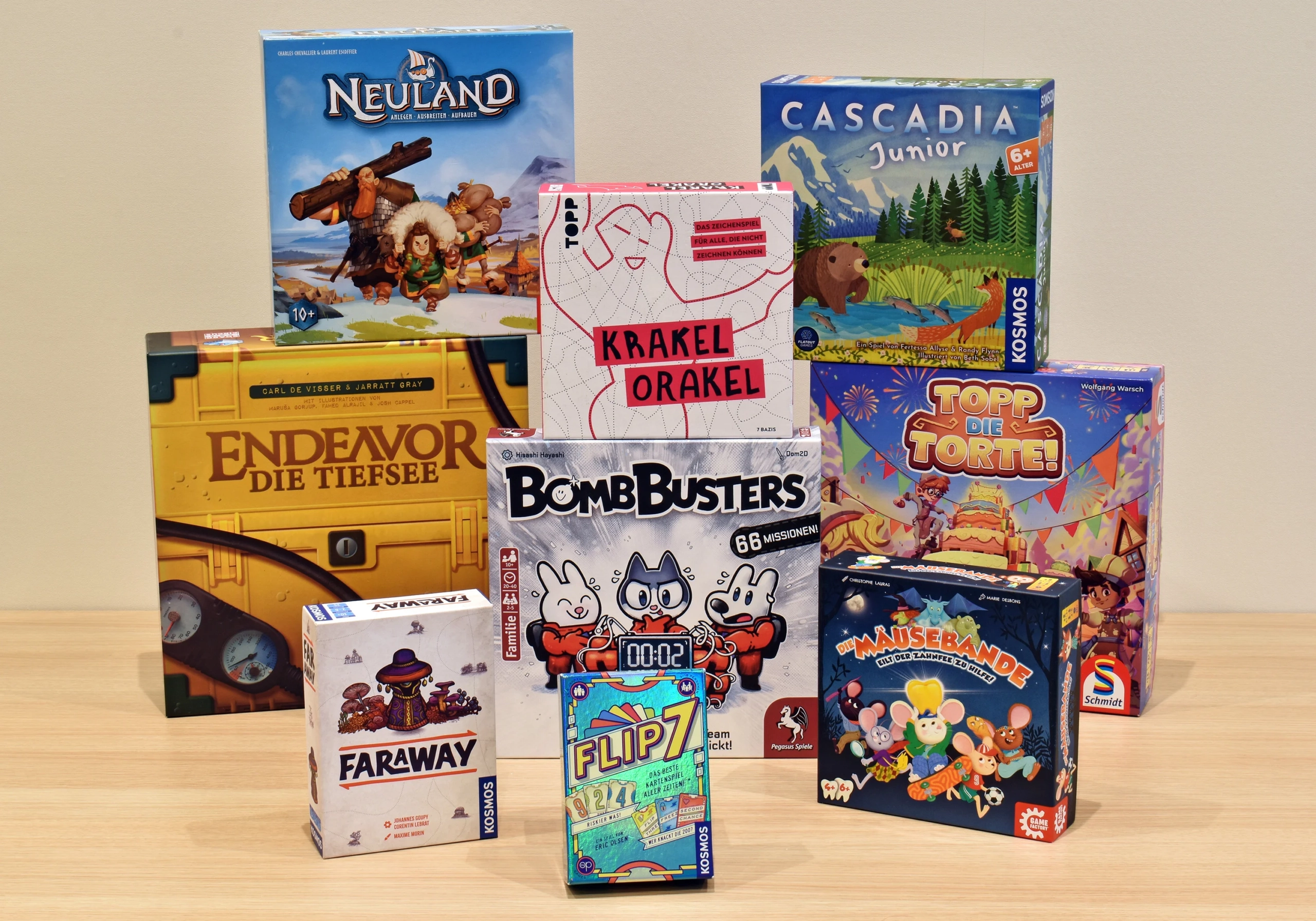 Verschiedene Brettspielverpackungen, darunter Neuland, Faraway und BombBusters, auf einem Tisch angeordnet.