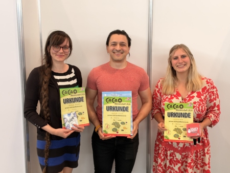 Drei Sieger des Cacao-Turniers 2026 halten ihre Urkunden; Alexandru Umlauft gewann, Christine Köhler belegte Platz zwei.
