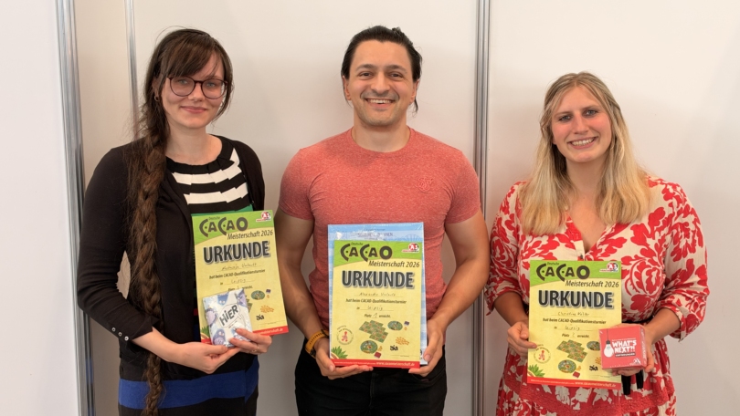 Drei Sieger des Cacao-Turniers 2026 halten ihre Urkunden; Alexandru Umlauft gewann, Christine Köhler belegte Platz zwei.